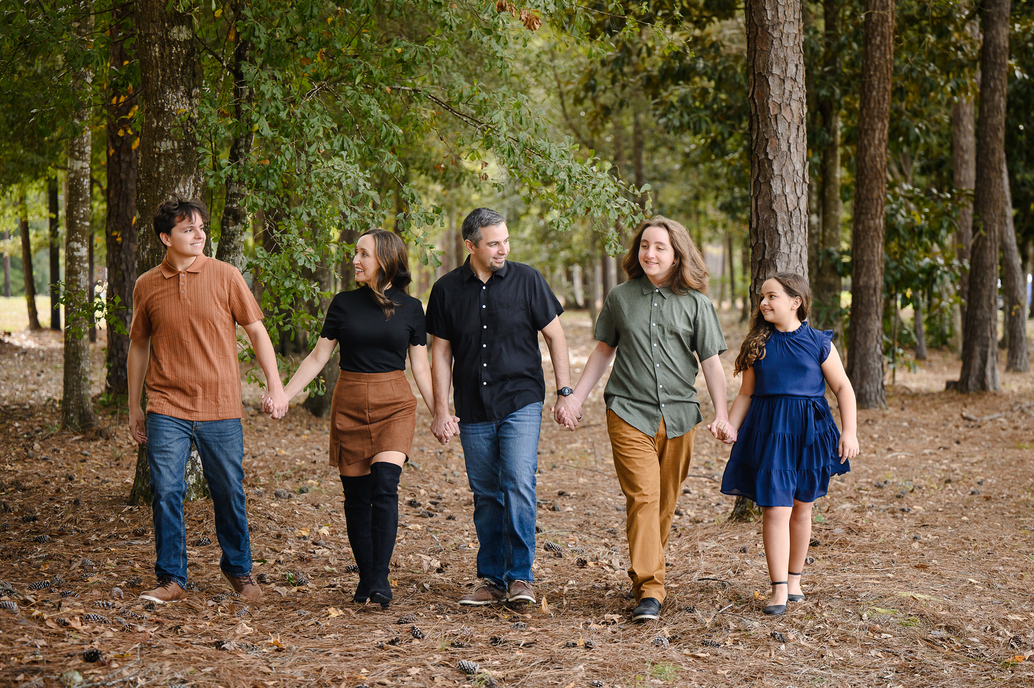 The Faison family walking together among the pines
